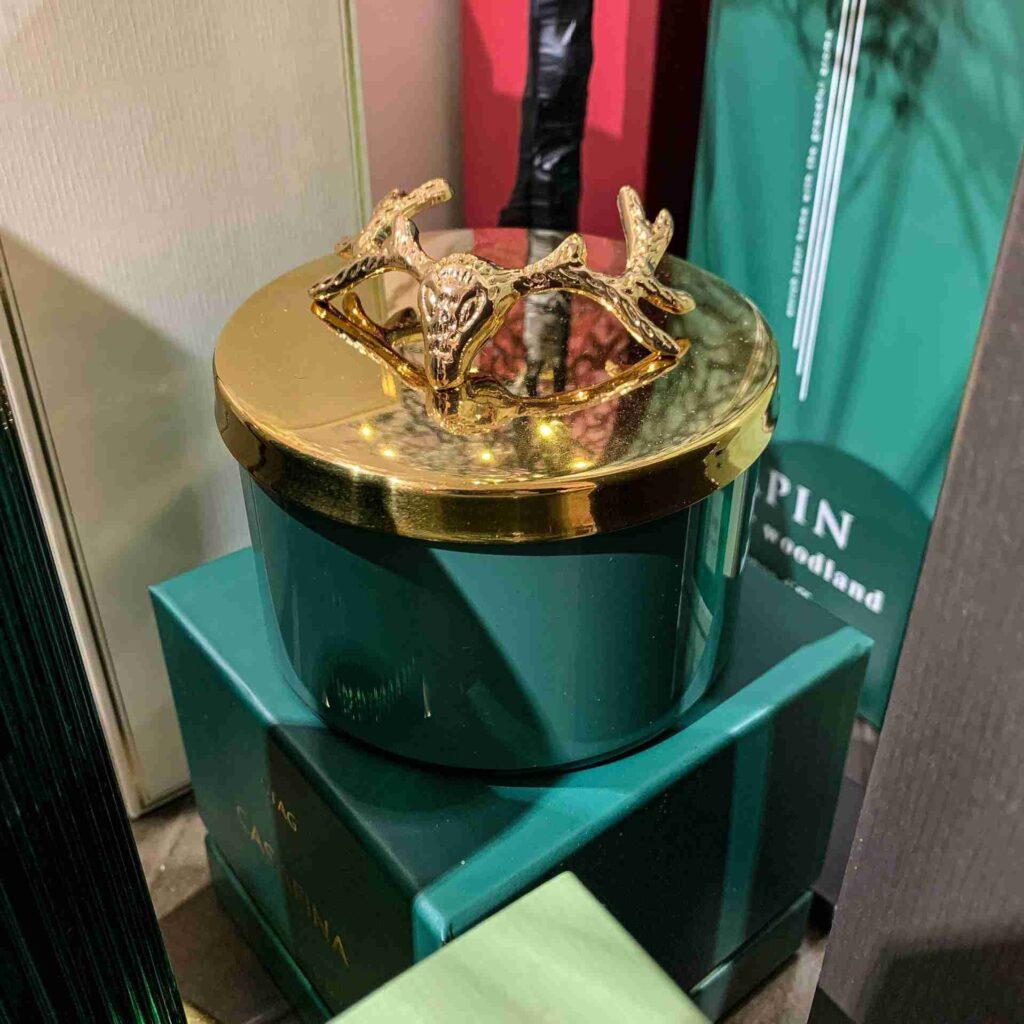 Luxurious scented candle with a casfina stag pine on gold glass and a green base.